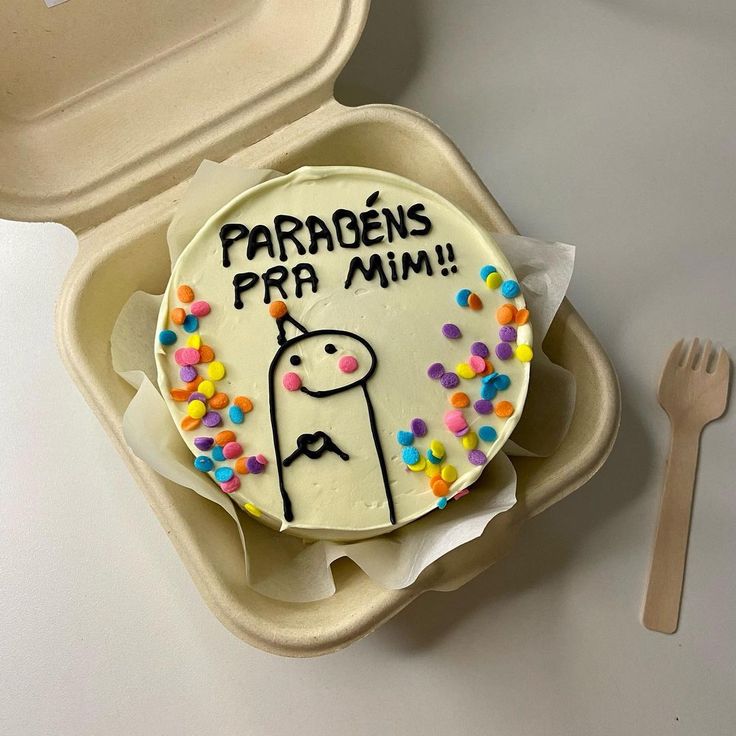 a cake in a container with the words parabens pra mim on it