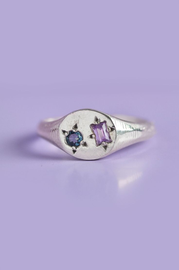 Experience the perfect blend of elegance and playfulness with our Delicate Pickles Mini Signet. Its eye-catching gemstones, including a mesmerizing blue-green Sapphire and an Amethyst, star-set in the face, make it a must-have for those who love to have fun with their jewellery. Use the drop down to select your ring size.If you are unsure of your ring size refer to our size guide. Please select your ring size carefully, and reach out if you have any questions. Details925 Sterling SilverHandcraft Signet Ring With Gemstones, Modern Multi-stone Sapphire Jewelry, Blue Amethyst Multi-stone Jewelry, Purple Multi-stone Gemstones For Gift, Blue Amethyst Jewelry With Gemstone Accents, Blue Multi-stone Amethyst Ring As Gift, Blue Amethyst Birthstone Jewelry, Blue Oval Amethyst Jewelry, Formal Blue Amethyst Ring