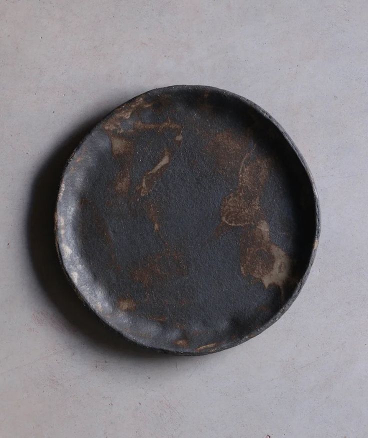 an old metal plate sitting on top of a table