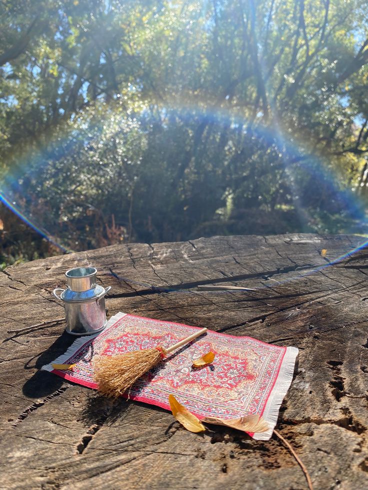 an open book sitting on top of a wooden table next to a cup and brush