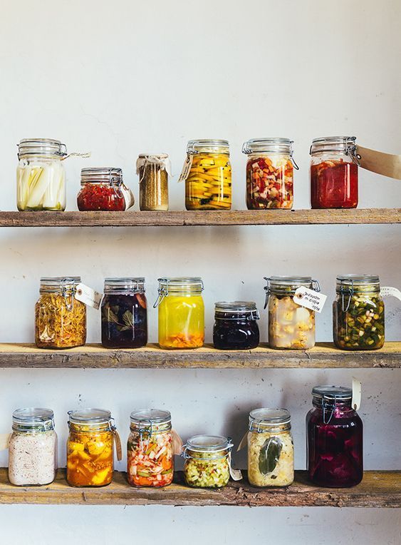 several shelves filled with different types of food and drinks in jars on top of each other