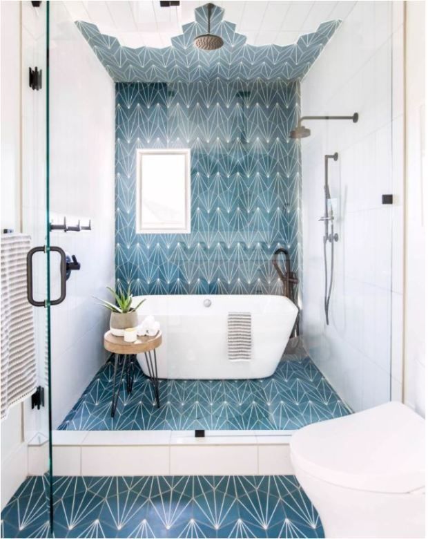 a white bath tub sitting under a bathroom mirror