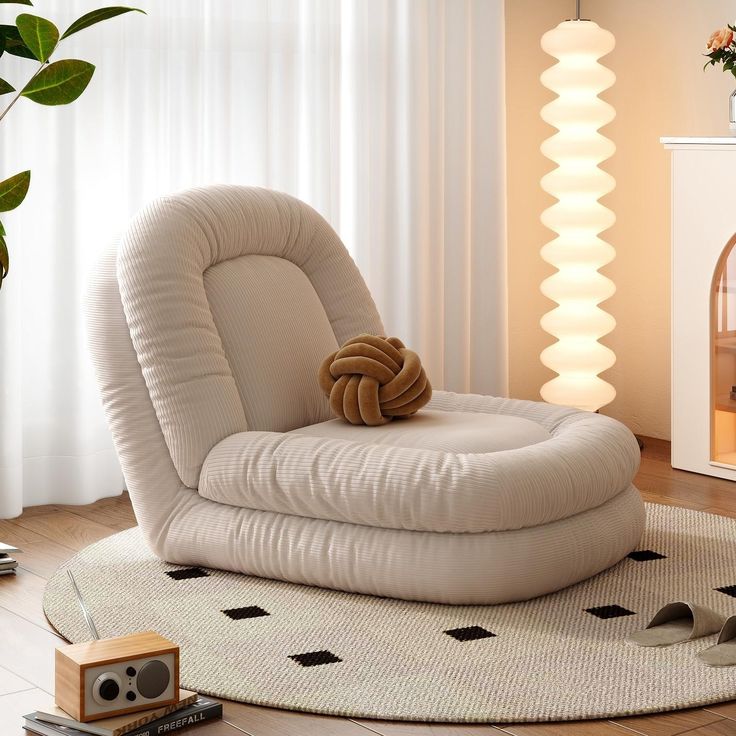 a chair with a pillow on top of it in front of a fire place next to a potted plant