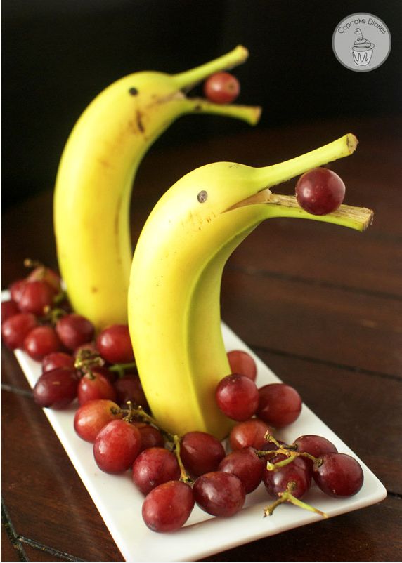 two bananas and some grapes on a plate