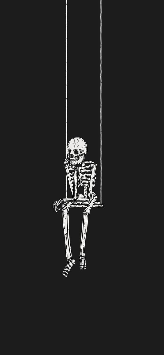 a skeleton sitting on a swing in the dark