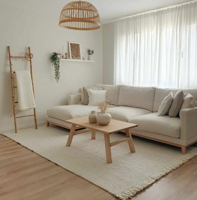 a living room with a white couch and wooden coffee table in front of a window