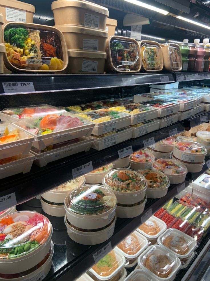 there are many containers of food on display in the case at this grocery store that is filled with different foods