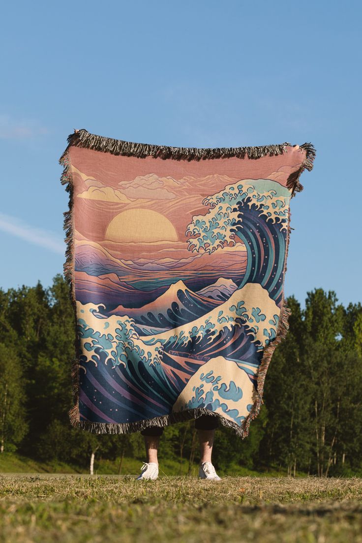 a giant blanket with the great wave on it is hanging in front of some trees