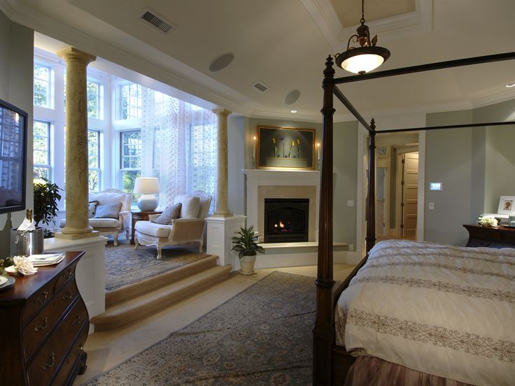 a bedroom with a bed, fireplace and stairs leading to the second floor area in front of it