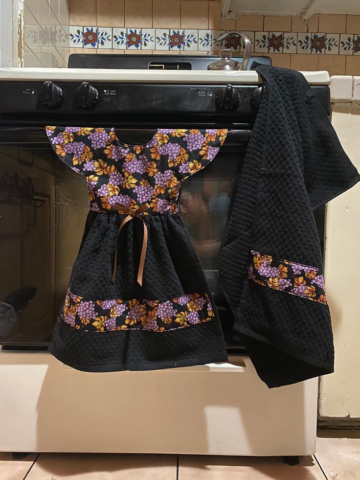 an oven with two black towels hanging from it's front