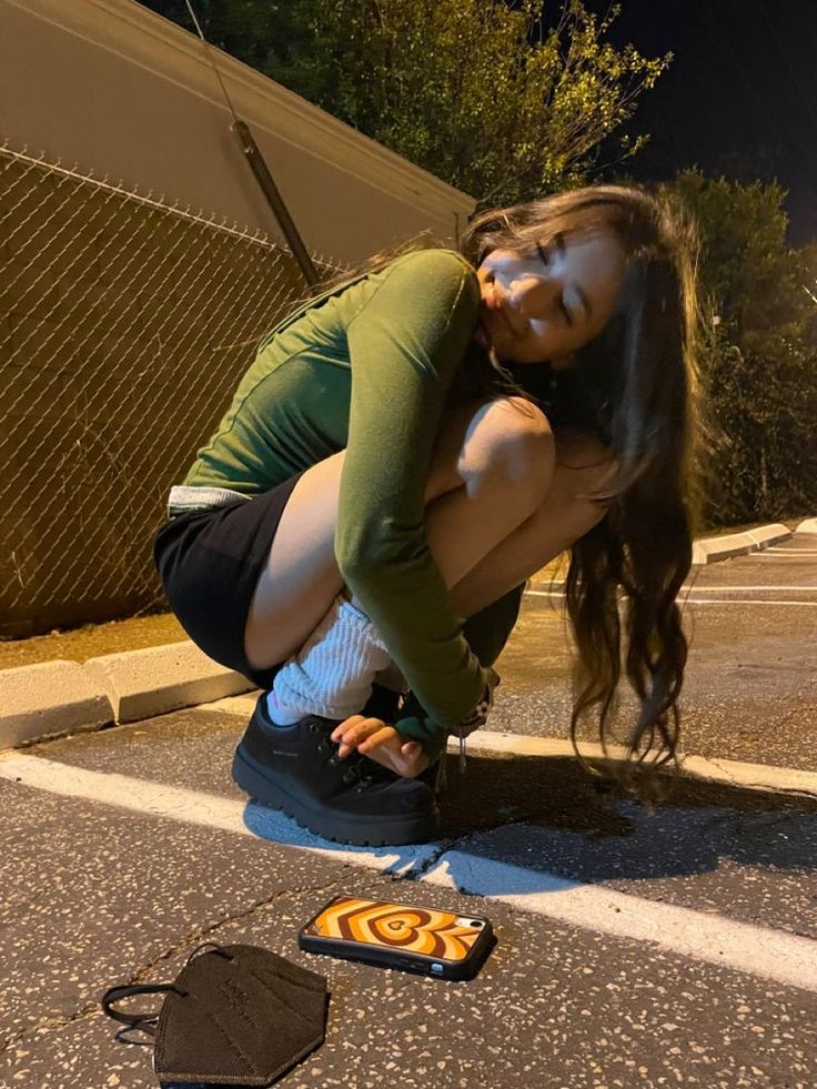 a woman kneeling on the ground next to an object