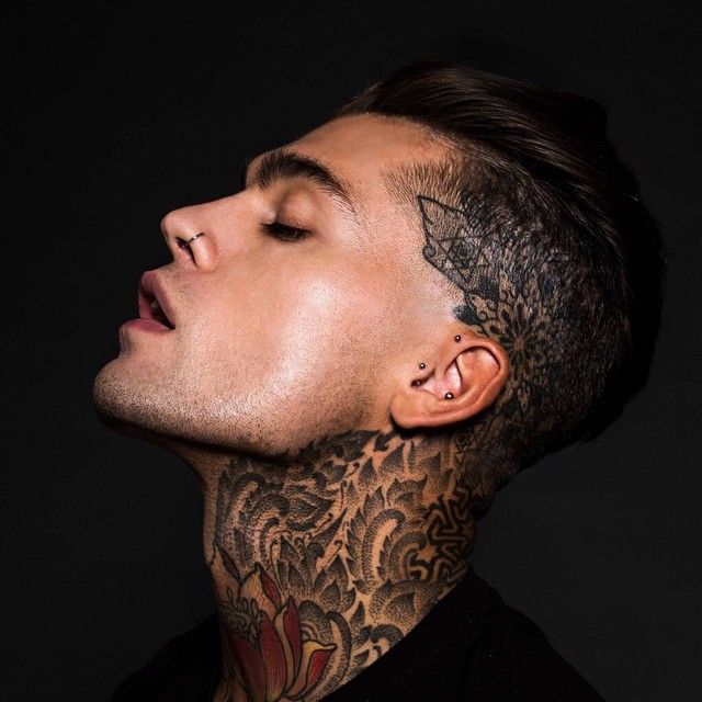 a man with tattoos on his face and neck