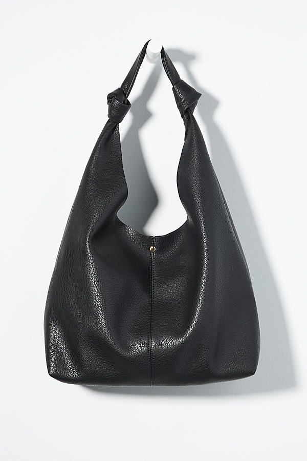 This oversized tote is your new BFF. Tied with two playful knots, this just-right sized, slouchy silhouette is designed to hold all your essentials (and more!) effortlessly – and with a touch of oh-so-fashionable flair. | The Love Knot Slouchy Bag by Anthropologie in Black, Women's, Polyurethane Slouchy Tote, Slouchy Bag, Slouch Bags, Minimalist Accessories, Laptop Bag For Women, Black Leather Tote Bag, Faux Leather Bag, Oversized Tote, Black Leather Tote