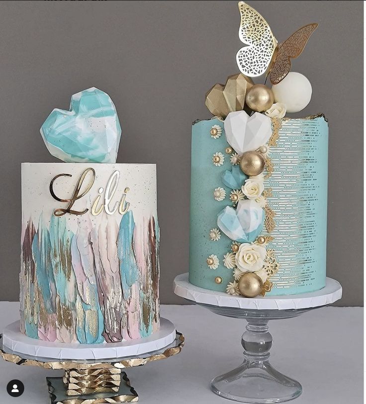 two cakes decorated with gold, blue and white decorations