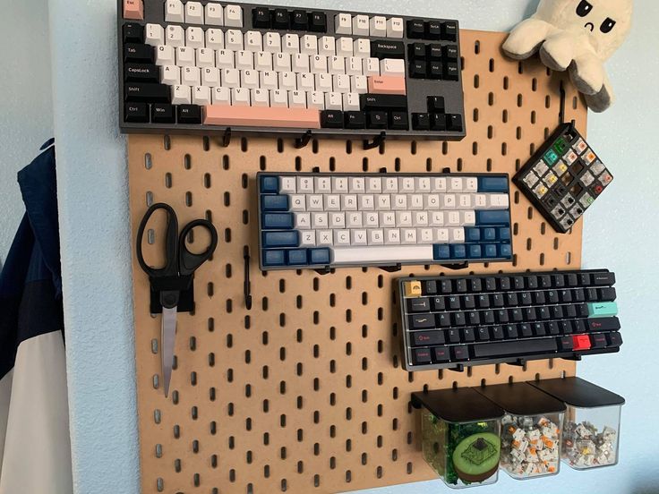 a peg board with several different types of keyboards and mouses attached to it, hanging on the wall