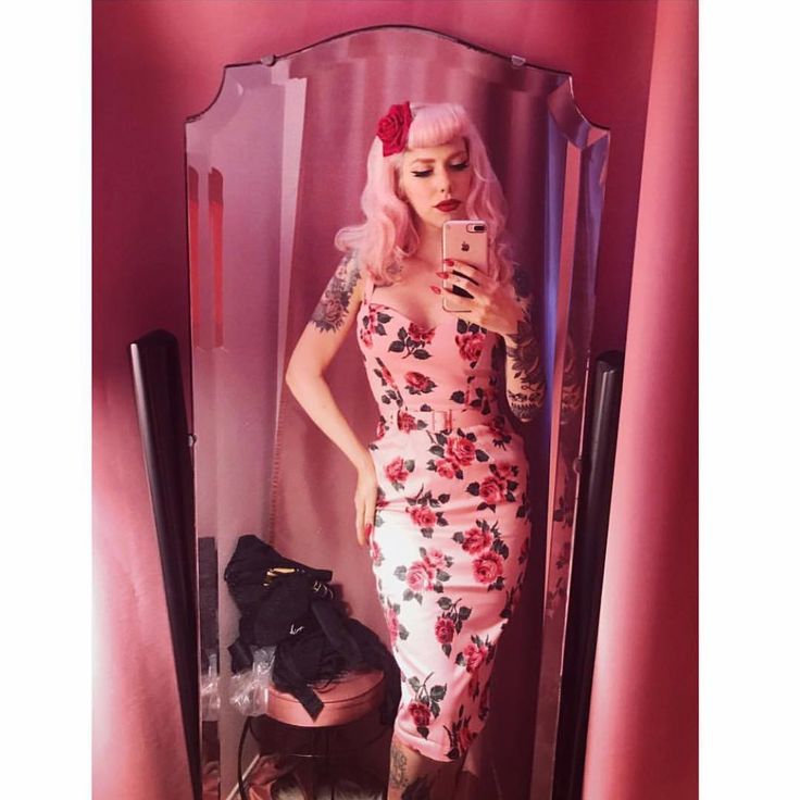 a woman with pink hair is taking a selfie in a mirror wearing a floral dress