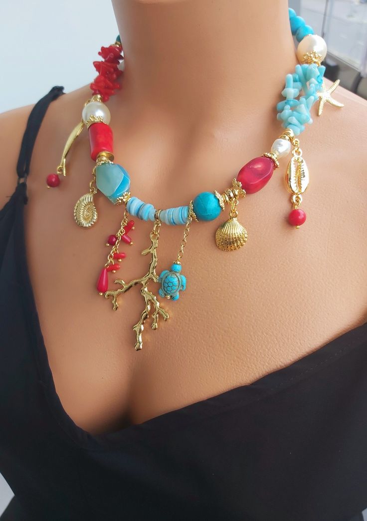 📍 Description :  The special design necklace has been designed with raw Coral,gemstone in red colour, raw Coral in blue colour, pearl and blue Turquoise gemstone.  💥 The colours of the stone may differ slightly in photo shoots caused by lighting and reflections. The necklace is Modern chunky statement gemstone beaded asymetrical necklace for women. The necklace does not stretch and well kept its shape. ✂ Materials : The natural stones used are; red raw  Coral and blue Turquoise gemstones.  The chain and gold-colored materials used are 14 carat gold plated on brass and do not tarnish. 📐 Dimensions : The necklace has a length of 42 centimeters/17 inç and can be adjusted using an extention cord. The weight of the necklace is 106 gr. 🧹 Care of the necklace: Although my products are durable Red Handmade Dangle Charm Necklaces, Handmade Red Dangle Charm Necklaces, Handmade Red Bohemian Charm Necklaces, Beach Jewelry With Red Gemstone Beads, Red Gemstone Beads Jewelry For Beach, Red Gemstone Bead Jewelry For The Beach, Beach Red Gemstone Beads Jewelry, Unique Red Jewelry With Beaded Chain, Unique Beaded Chain Jewelry For Beach