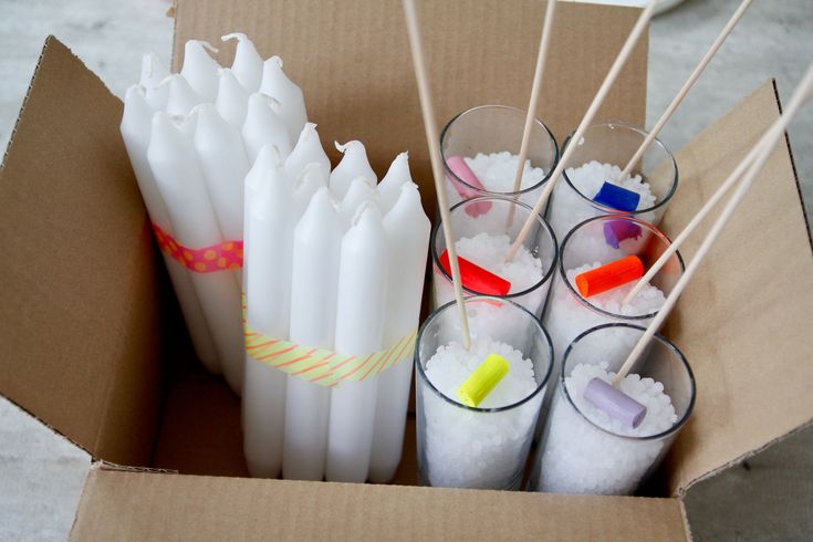 there are many drinks in the box with sticks sticking out of it and some ice