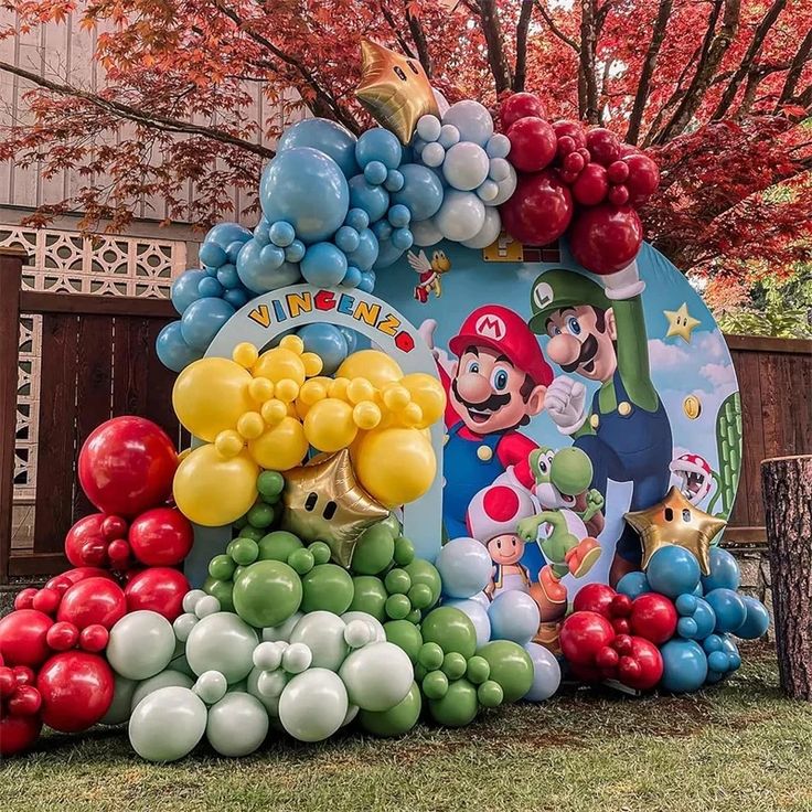 a large balloon arch with mario and luigi's house on it in front of a tree