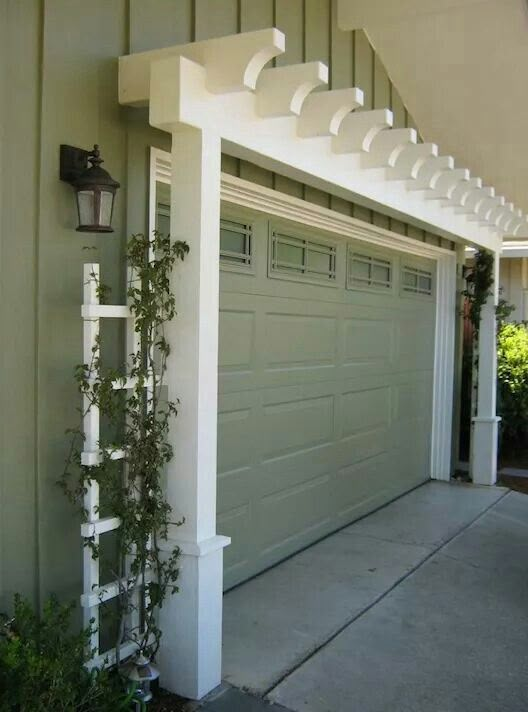 a garage with a white trellis on the side