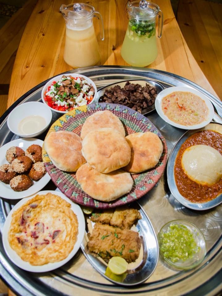 an assortment of food is on a silver platter with bowls and sauces around it