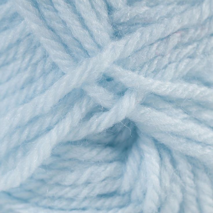 a close up view of a ball of yarn in light blue color with white crochet