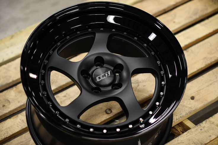 a close up of a black wheel on a wooden bench