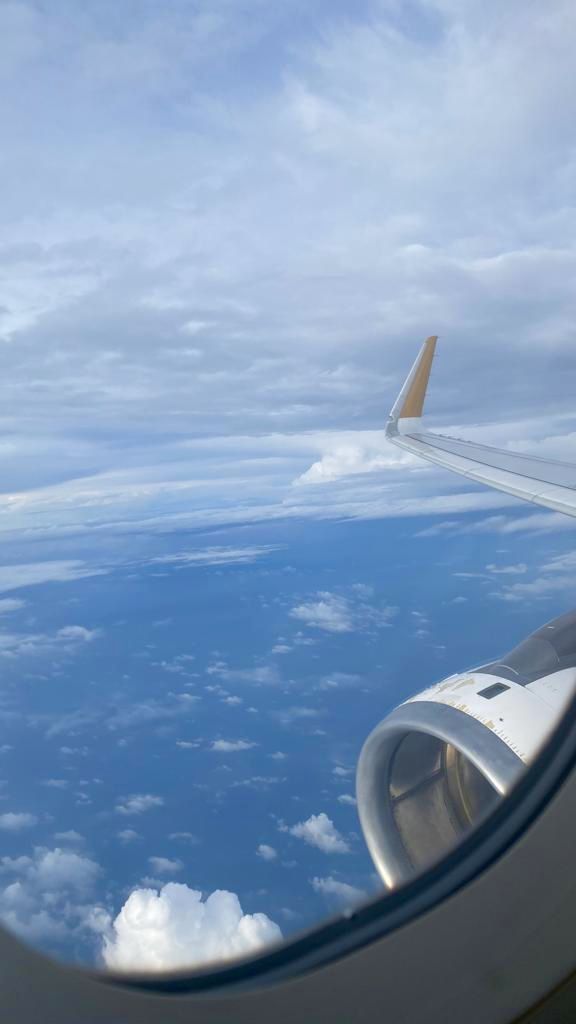 the wing of an airplane flying over clouds