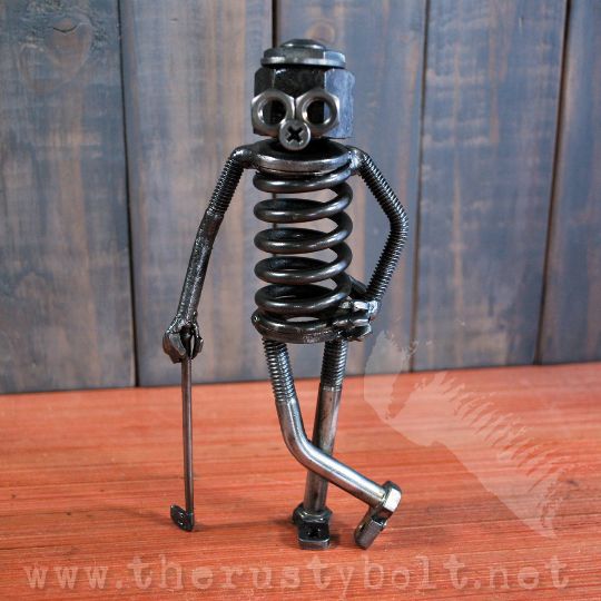 a small metal figure standing on top of a wooden table