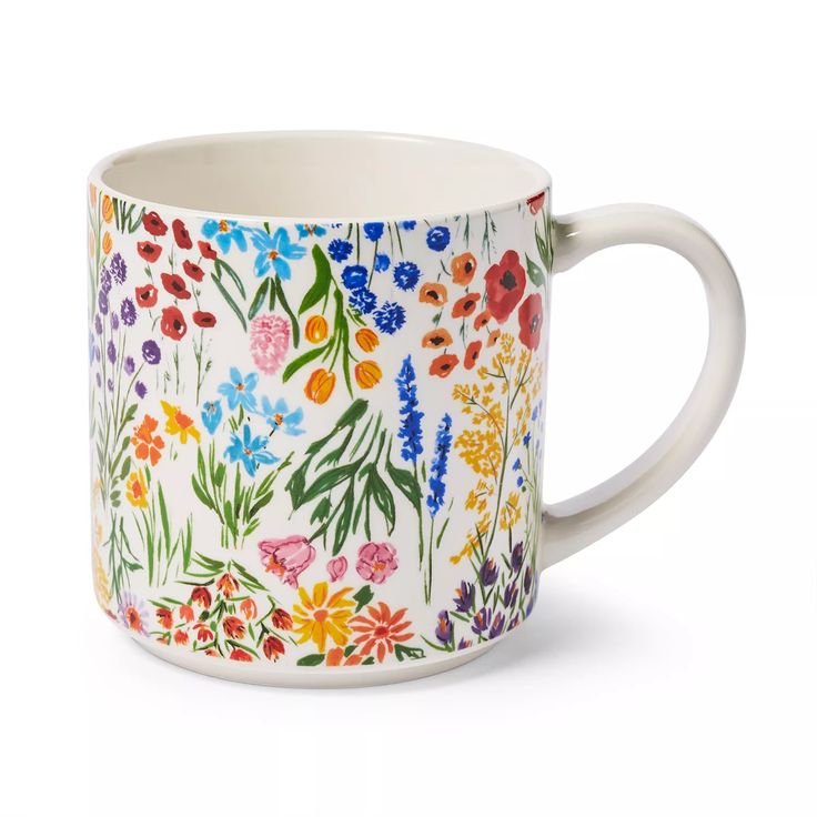 a coffee mug with colorful flowers painted on it's side and inside the cup