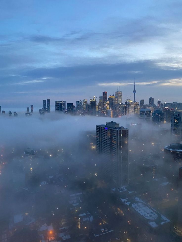 the city skyline is covered in fog and smoggy