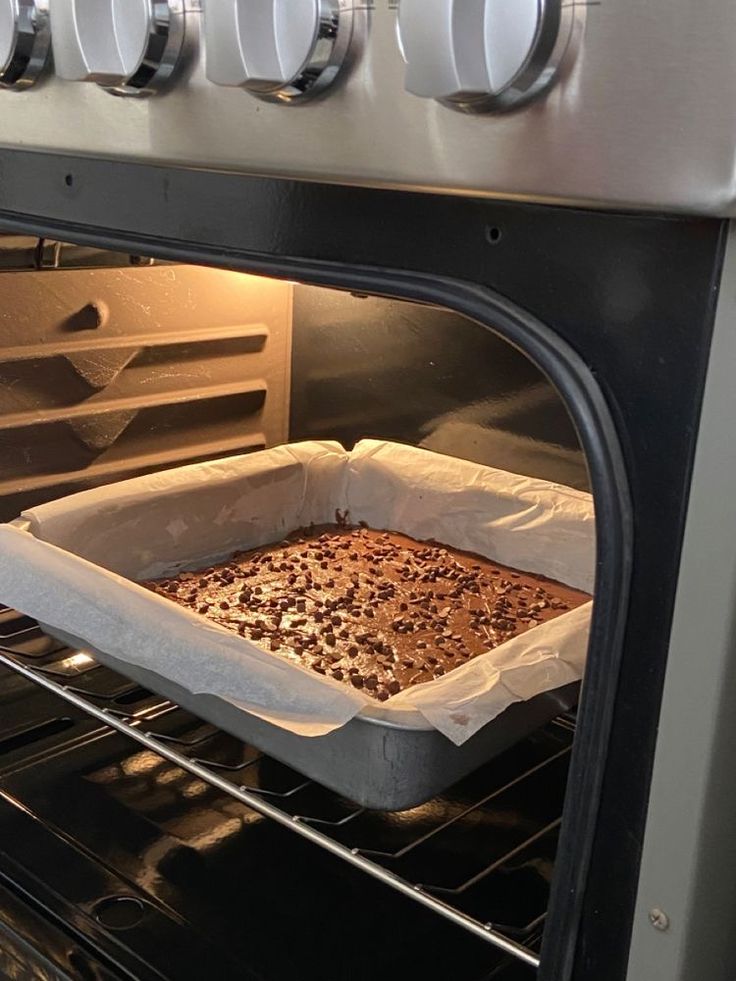 an open oven with a baking dish in it's door and the light on