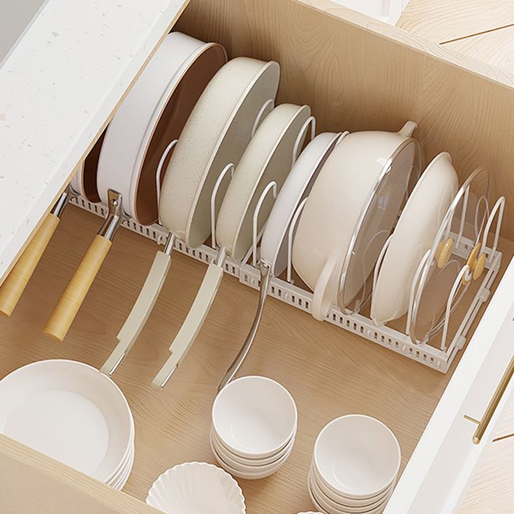 an open drawer filled with white dishes and plates