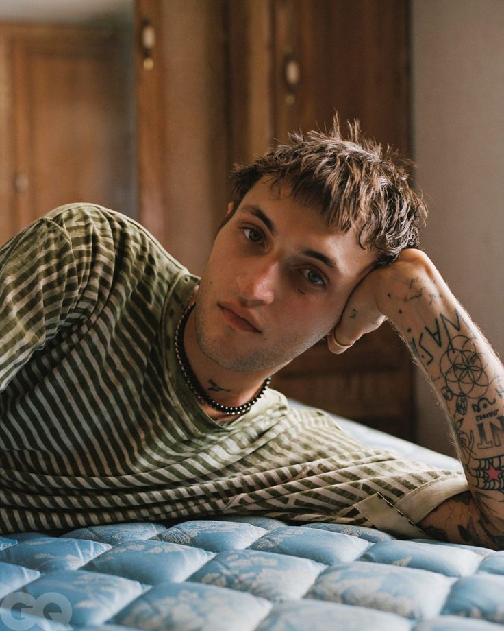 a young man laying on top of a bed