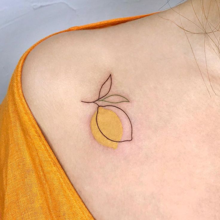 a close up of a person's shoulder with a small tattoo design on it