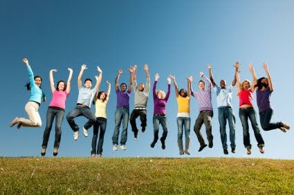 a group of people jumping in the air with their arms up and hands raised above them