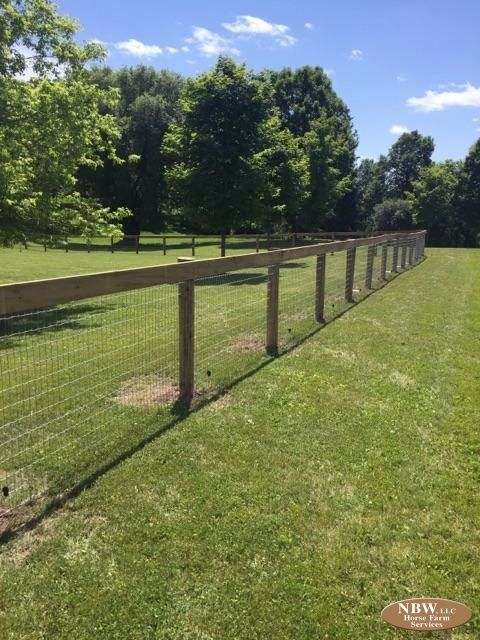 a long fence in the middle of a grassy field