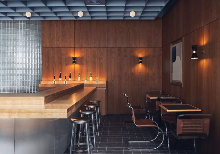 an empty bar with stools and wooden walls