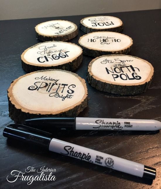 some wooden slices with writing on them and marker pens sitting next to eachother