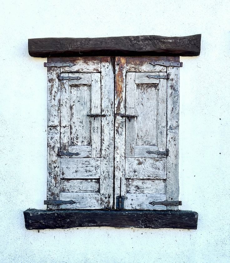 an old window with two wooden doors on it