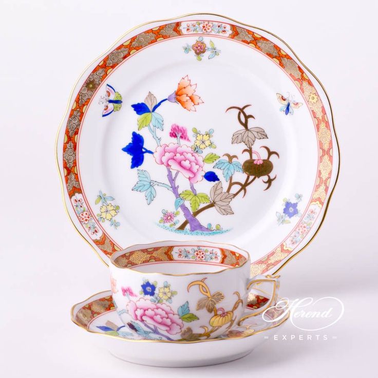 a cup and saucer decorated with colorful flowers on white background, side by side