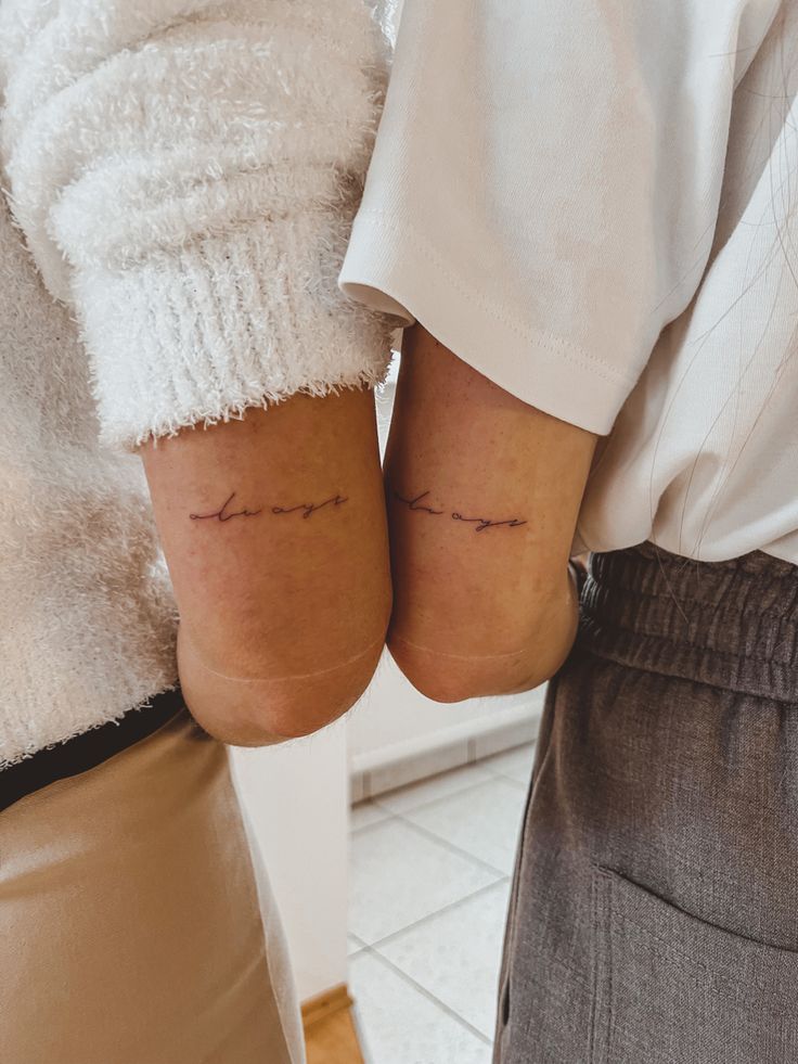 two people standing next to each other with tattoos on their arms and legs that say love