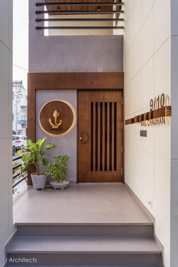 an entry way with stairs leading up to the second floor and potted plants on the steps