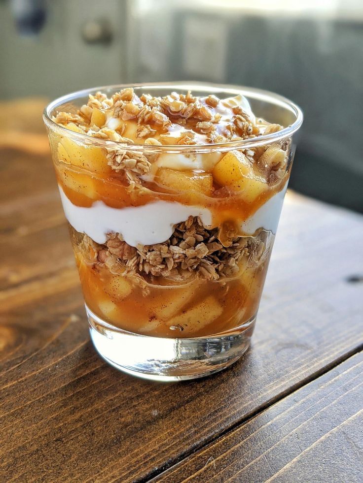 a dessert in a glass on top of a wooden table