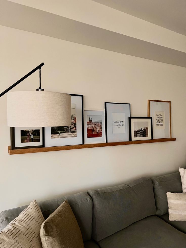 a living room filled with furniture and framed pictures on the wall above it's couch