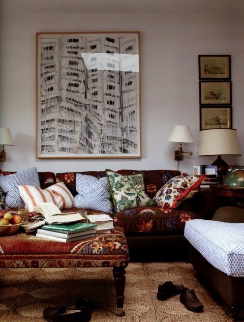 a living room filled with lots of furniture next to a painting on the wall and floor