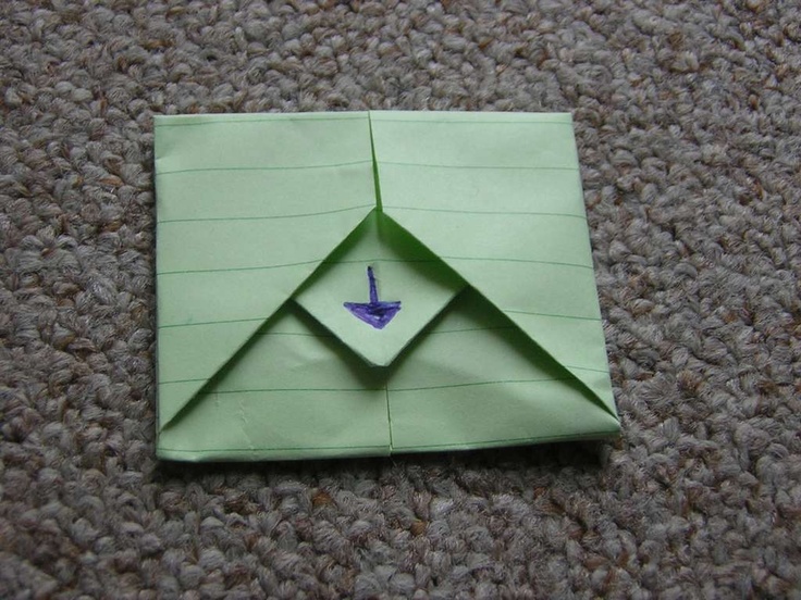 an origami bird on top of a piece of green paper with a blue tip