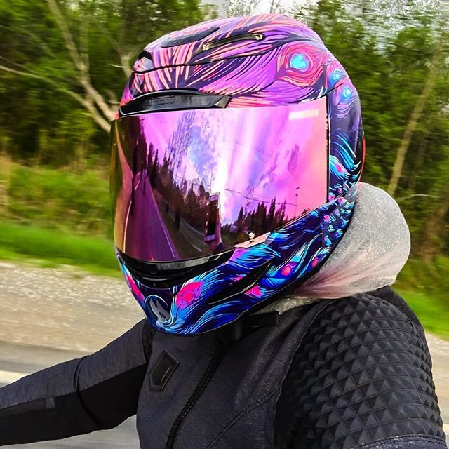 a person riding a motorcycle with a colorful helmet on