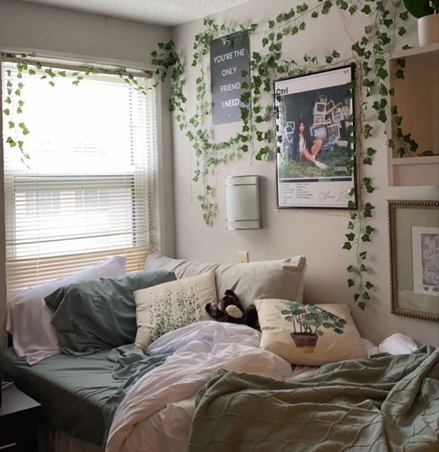 an unmade bed in a bedroom with ivy growing on the wall