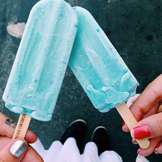 two people holding popsicles in their hands